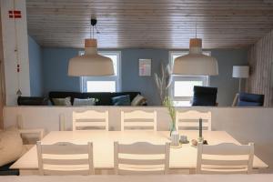 a dining room with a table and chairs and a couch at Klitrosen Coastal Hideout in Thisted