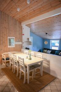 a dining room with a white table and chairs at Klitrosen Coastal Hideout in Thisted