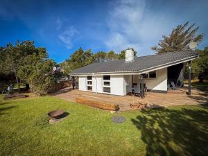 a white house with a large yard with a yard at Klitrosen Coastal Hideout in Thisted
