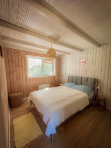 a bedroom with a large bed in a cabin at Klitrosen Coastal Hideout in Thisted