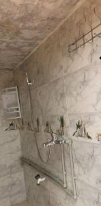 a shower in a bathroom with a marble wall at Tinejdad Auberge in Tinejdad +41 photos