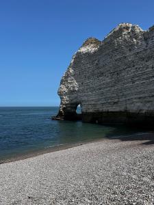 a rock formation on a beach near the water at Manava Etretat Sea ViewHouse in Étretat