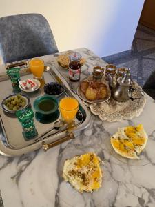 a table topped with plates of food and orange juice at Tinejdad Auberge in Tinejdad