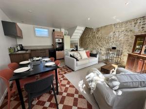 a kitchen and living room with a table and a couch at Manava Etretat Sea ViewHouse in Étretat