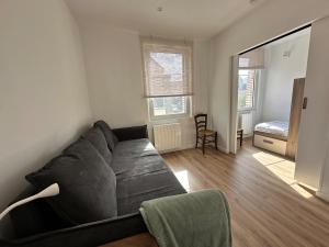 a living room with a black couch and a bedroom at Manava Etretat Sea ViewHouse in Étretat