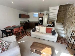 a living room with a white couch and a table at Manava Etretat Sea ViewHouse in Étretat