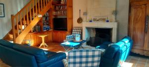 a living room with blue couches and a fireplace at Logis de Chenac - Chambres et table d'hôtes in Chenac Saint Seurin D'uzet