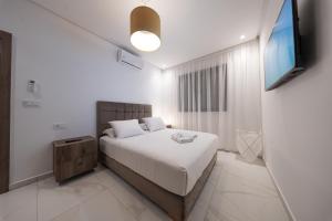 a bedroom with a bed and a flat screen tv at Résidences Nador in Nador