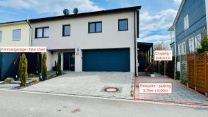 a white house with a garage with signs on it at FeWo Souterrain TT-Bodensee in Tettnang