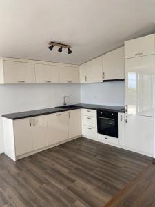 a kitchen with white cabinets and a black counter top at Stone Villa in Zagrađe