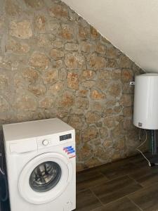a washing machine in a room with a stone wall at Stone Villa in Zagrađe