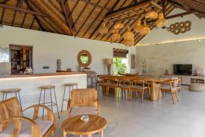 a kitchen and dining room with wooden tables and chairs at Villa Pascaline in Mengwi