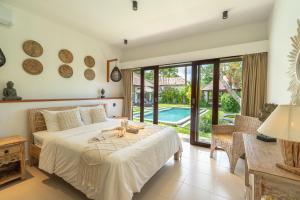 a bedroom with a bed and a view of a pool at Villa Pascaline in Mengwi +67 photos