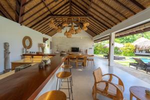 an open kitchen and dining room with a table and chairs at Villa Pascaline in Mengwi