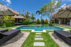 a swimming pool in a villa with a resort at Villa Pascaline in Mengwi