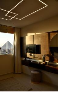 a living room with a television and a window at Makan Pyramids View in Cairo