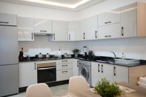 a kitchen with white cabinets and a dishwasher at Résidences Nador in Nador