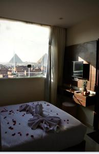 a bedroom with a bed and a large window at Makan Pyramids View in Cairo +43 photos