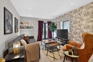a living room with a couch and a tv at Central Belfast Apartments: Citygate in Belfast