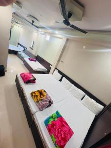 two beds in a room with flowers on them at Hotel Mukhiya Palace in Ujjain