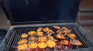 a grill with chicken and other food on it at Vidman Homey Huts in Tindummal +24 photos