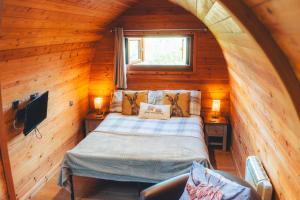 a bedroom with a bed in a wooden cabin at Hatterall View Glamping Pod in Abergavenny