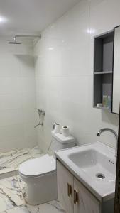 a white bathroom with a toilet and a sink at Hillawi Private Desert Camp in Aqaba