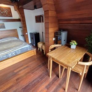 a room with a bed and a wooden table at Villa AMPO unique Gazebo Flat in Munggu
