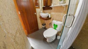 a small bathroom with a toilet and a sink at Villa AMPO unique Gazebo Flat in Munggu