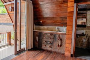 a kitchen with wooden walls and a sink and a window at Villa AMPO unique Gazebo Flat in Munggu +6 photos