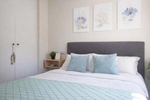 a bedroom with a bed with blue and white pillows at Fenals Calm - con piscina in Lloret de Mar +22 photos