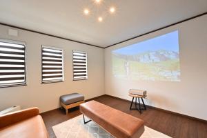 a living room with a large screen on the wall at Manabi-WAN Takayama in Takayama