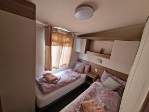 a small room with two beds and a window at Durdlee Door, D27, Main Rd, West Lulworth, Wareham BH20 5PU in West Lulworth