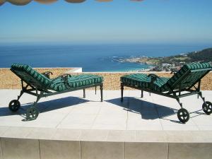 two green benches sitting on top of a roof at Camps Bay Villa in Cape Town