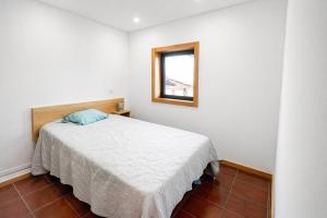 a bedroom with a white bed and a window at Quintinha de Sá in Arnoso