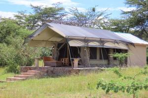 a tent in the middle of a field at Odupoi Lodge in Maji Moto