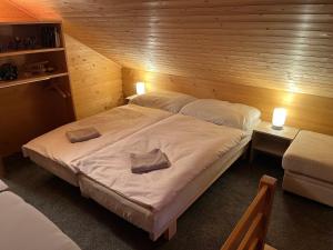 a bedroom with a large bed with two pillows on it at Srub u Hadiny in Pelhřimov +8 photos
