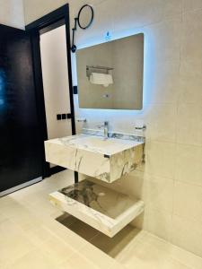 a bathroom with a marble sink and a mirror at الشموخ بارك إن in Z̧alim +6 photos