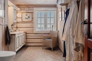 a bathroom with a toilet and a sink and a window at Eksklusiv tømmerhytte Spa Panoramautsikt in Aurdal +19 photos