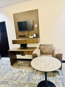 a living room with a couch and a tv and a table at الشموخ بارك إن in Z̧alim