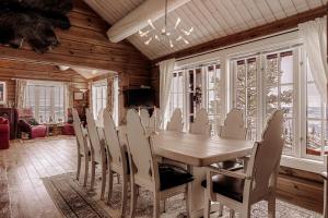 a dining room with a wooden table and chairs at Eksklusiv tømmerhytte Spa Panoramautsikt in Aurdal