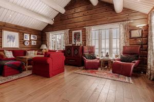 a large living room with red furniture and wooden walls at Eksklusiv tømmerhytte Spa Panoramautsikt in Aurdal