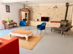 a living room with a couch and a table and chairs at Le jardin de Grignan in Réauville