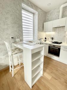 a white kitchen with a white island in a room at Rami studio apartment in Panevėžys