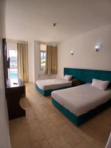 a hotel room with two beds and a window at Regency Hotel Sharm in Sharm El Sheikh