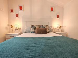 a bedroom with a large bed with a green blanket at Ático 32 in Lugo