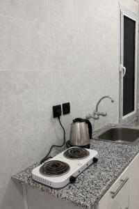 a kitchen counter with a tea kettle on a stove at استديو بتصميم سينمائي in Buraydah