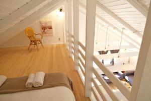 a attic room with a staircase and a chair at Bork Cozy Cottage in Hemmet