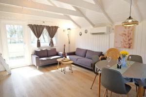 a living room with a couch and a table at Bork Cozy Cottage in Hemmet