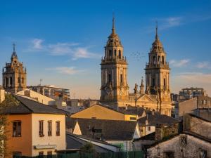 a view of two towers of a city with buildings at Ático 32 in Lugo